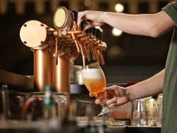 Someone pouring a pint of beer in a bar