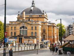A yellow building with a dome in a central area on a grey day