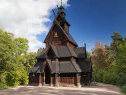 A small dark brown church building of several tiers